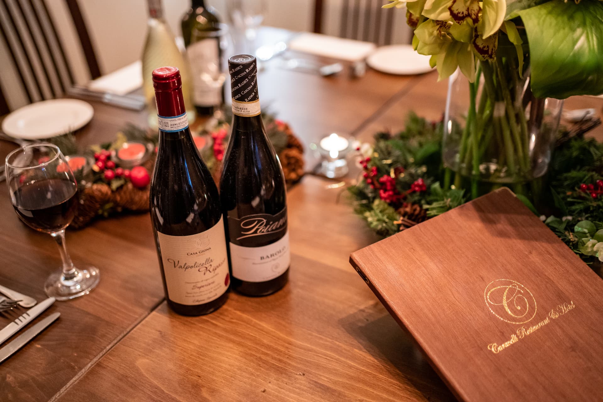 Caravelli Christmas table set with wine, festive greenery and the Old Manor menu